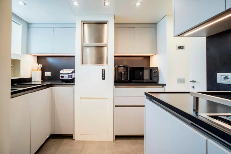  Yacht Photos Pics Modern kitchen in 2024 Sanlorenzo SX100 yacht with sleek cabinetry and appliances.