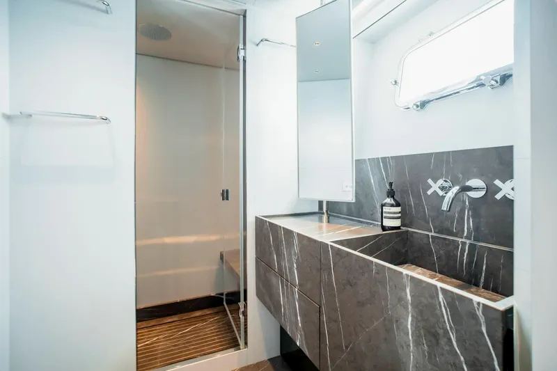  Yacht Photos Pics Luxurious bathroom in 2024 Sanlorenzo SX100 yacht with modern marble sink and sleek shower.