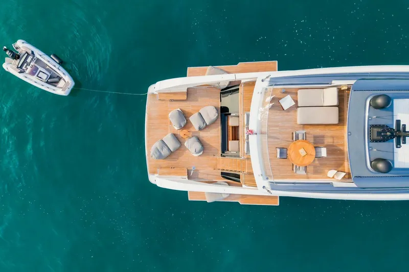  Yacht Photos Pics Aerial view of 2024 Sanlorenzo SX100 yacht with spacious deck and tender in blue water.