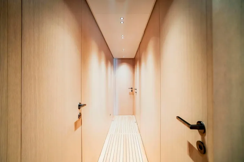  Yacht Photos Pics 2024 Sanlorenzo SX100 yacht interior hallway with sleek wooden design and modern lighting.