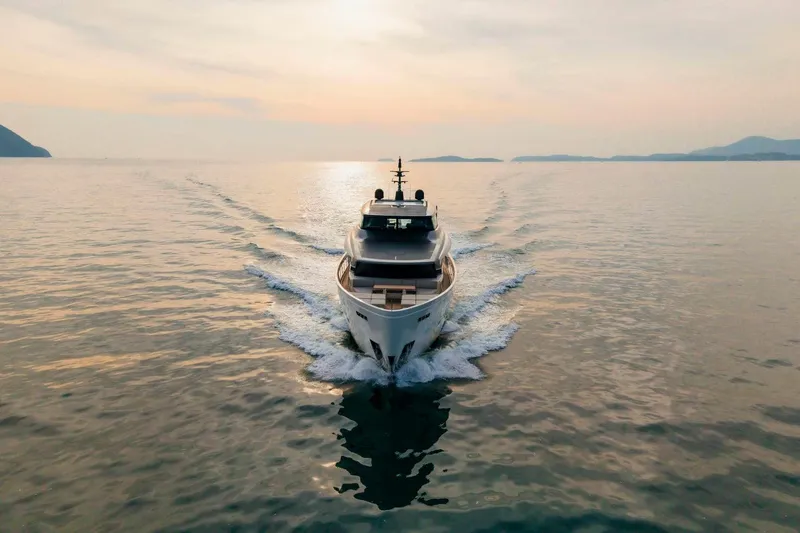  Yacht Photos Pics 2024 Sanlorenzo SX100 yacht cruising at sunset on calm waters.