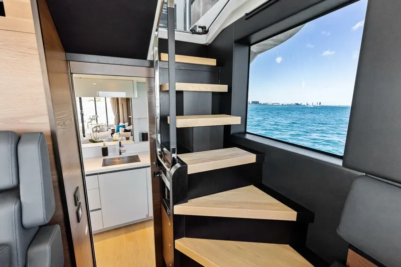 Fantasy Girl Yacht Photos Pics Interior of 2025 Absolute 75 Navetta yacht with modern staircase and ocean view.