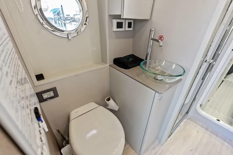 Fantasy Girl Yacht Photos Pics Modern bathroom in 2025 Absolute 75 Navetta yacht with glass sink and porthole.