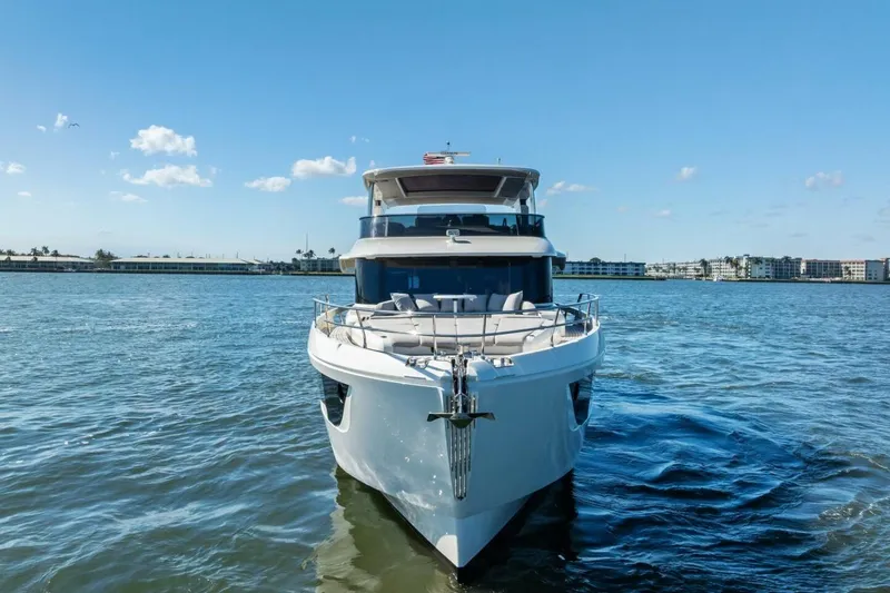 Fantasy Girl Yacht Photos Pics Front view of 2025 Absolute 75 Navetta yacht on calm water under clear blue sky.