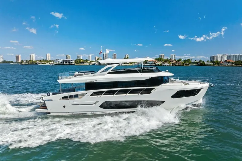 Fantasy Girl Yacht Photos Pics Luxury Absolute 75 Navetta yacht cruising on water, 2025 model, with city skyline backdrop.