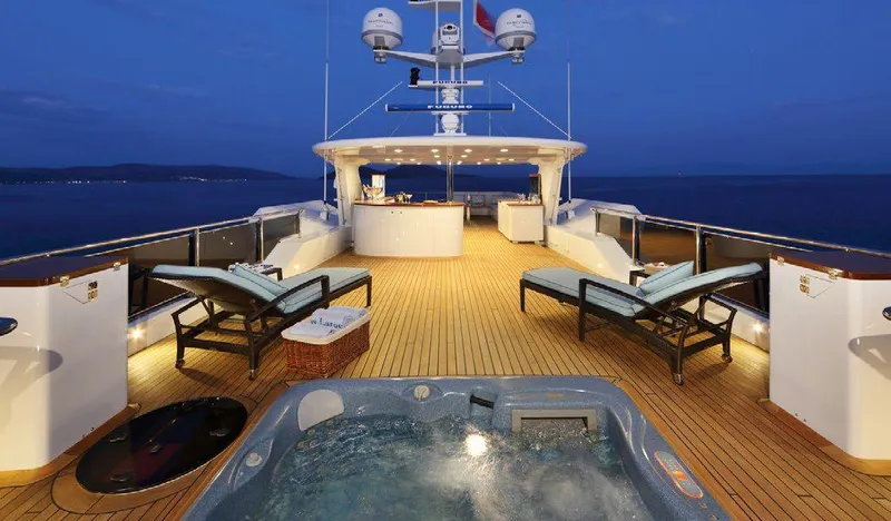  Yacht Photos Pics Luxurious 1987 Benetti 50 CUSTOM yacht deck with jacuzzi and lounge chairs at sunset.