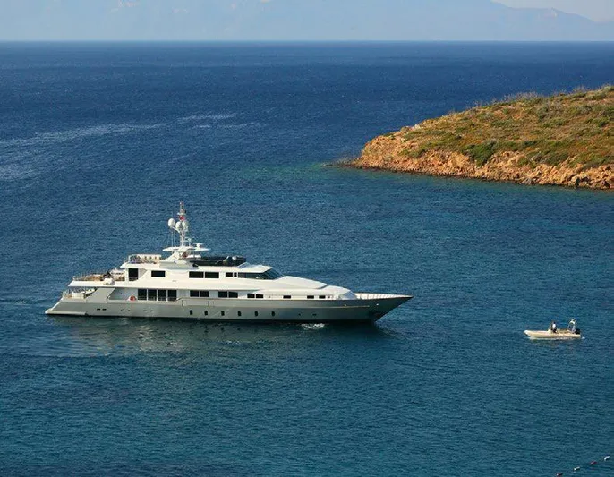  Yacht Photos Pics Luxury Benetti 50 CUSTOM yacht from 1987 cruising near a rocky coastline.