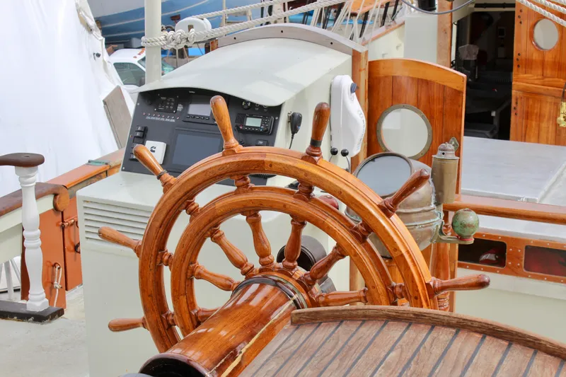 Hawaiian Chieftain Yacht Photos Pics Wooden helm of 1988 Custom Lahaina Welding Co. Square Topsail Ketch, showcasing nautical craftsmanship.