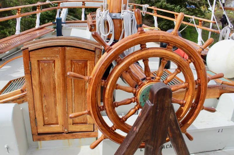 Hawaiian Chieftain Yacht Photos Pics Wooden ship wheel on 1988 Lahaina Welding Co. Square Topsail Ketch, showcasing nautical craftsmanship.