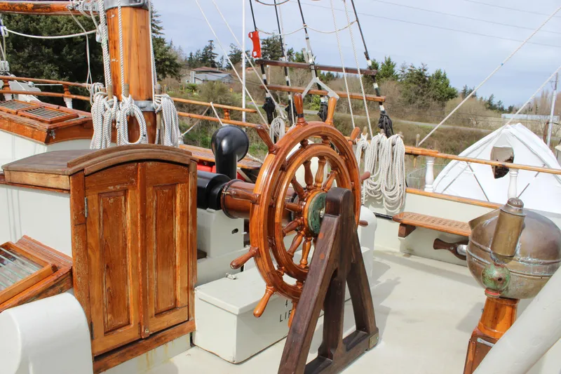 Hawaiian Chieftain Yacht Photos Pics Wooden helm of 1988 Custom Lahaina Welding Co. Square Topsail Ketch, with ropes and nautical equipment.
