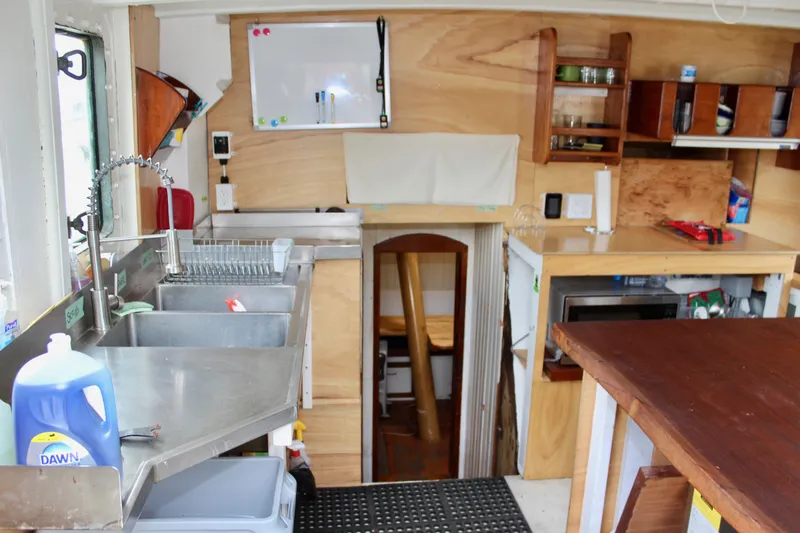 Hawaiian Chieftain Yacht Photos Pics Interior of 1988 Lahaina Welding Co. Square Topsail Ketch with kitchen and wooden cabinetry.