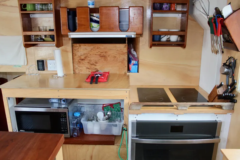 Hawaiian Chieftain Yacht Photos Pics Compact kitchen in 1988 Lahaina Welding Co. Square Topsail Ketch with microwave, stove, and storage shelves.