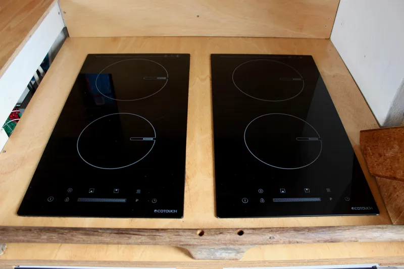 Hawaiian Chieftain Yacht Photos Pics Modern induction cooktop with four burners on a wooden countertop.