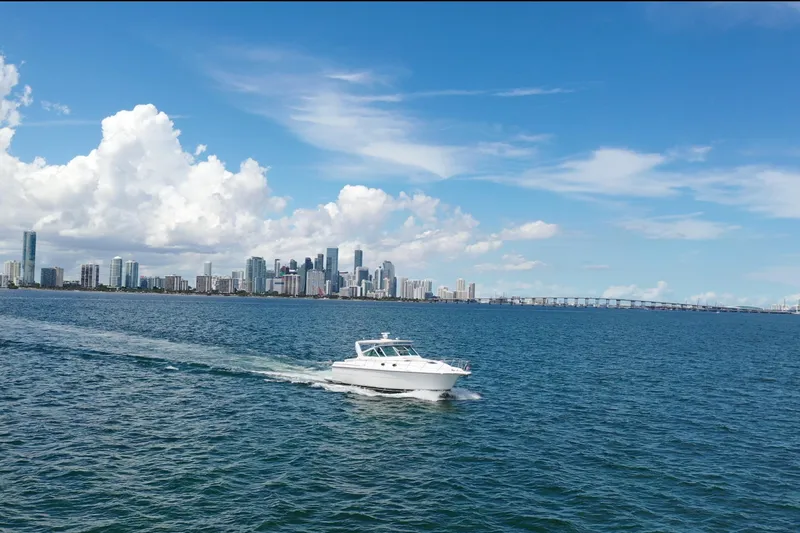  Yacht Photos Pics 1999 Tiara Yachts 4000 Express cruising on blue waters with city skyline backdrop.