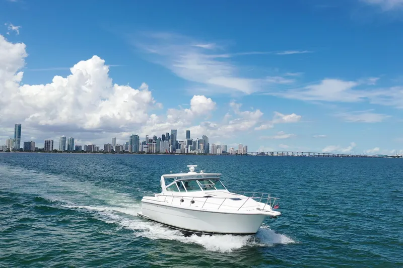  Yacht Photos Pics 1999 Tiara Yachts 4000 Express cruising on blue waters with city skyline backdrop.
