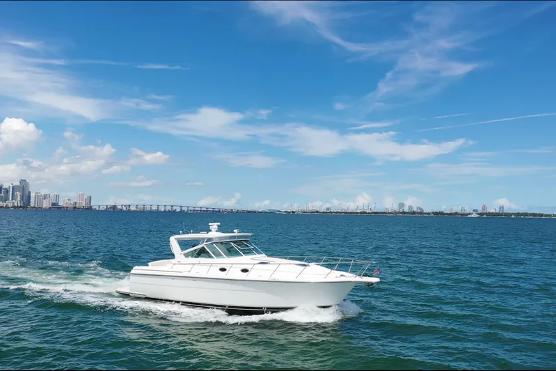  Yacht Photos Pics 1999 Tiara Yachts 4000 Express cruising on blue ocean with city skyline in background.