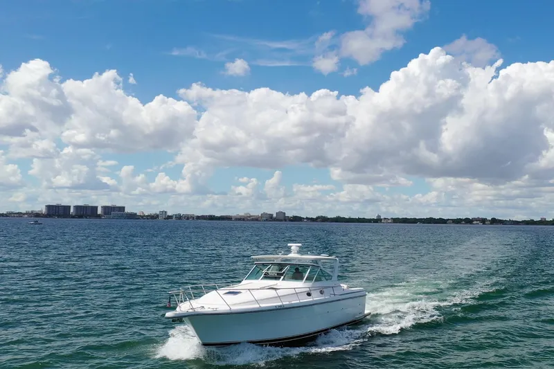  Yacht Photos Pics 1999 Tiara Yachts 4000 Express cruising on a sunny day with scenic city skyline.