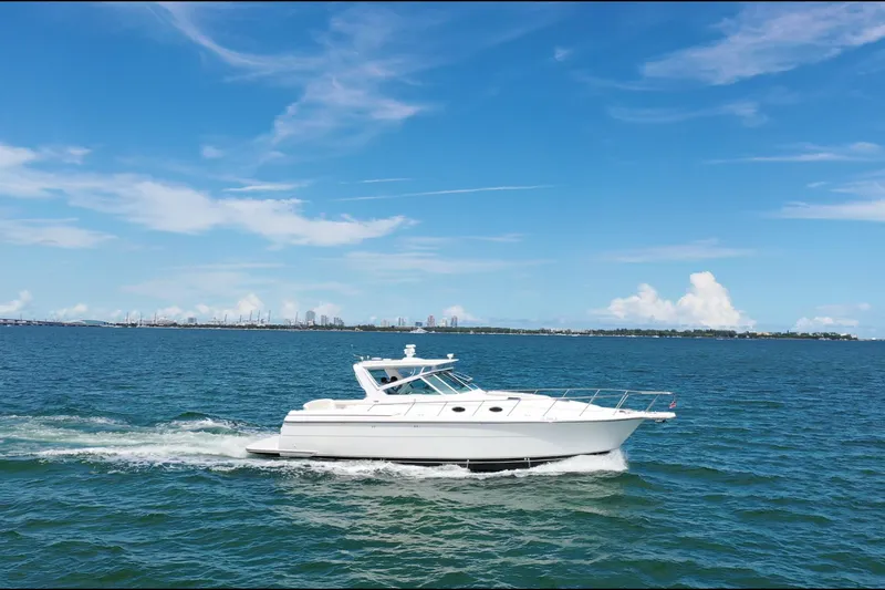  Yacht Photos Pics 1999 Tiara Yachts 4000 Express cruising on open water under a clear blue sky.