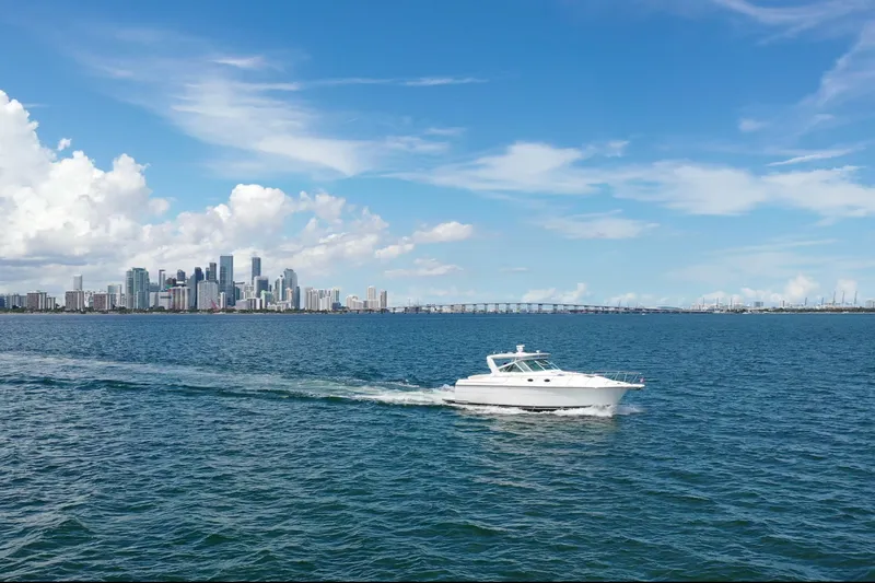  Yacht Photos Pics 1999 Tiara Yachts 4000 Express cruising near city skyline under blue sky.