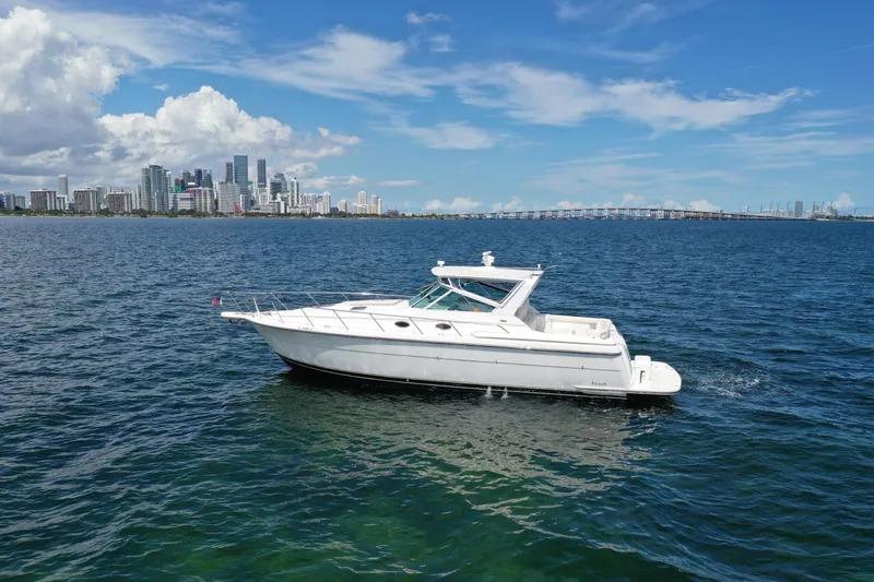  Yacht Photos Pics 1999 Tiara Yachts 4000 Express cruising on blue waters near a city skyline.