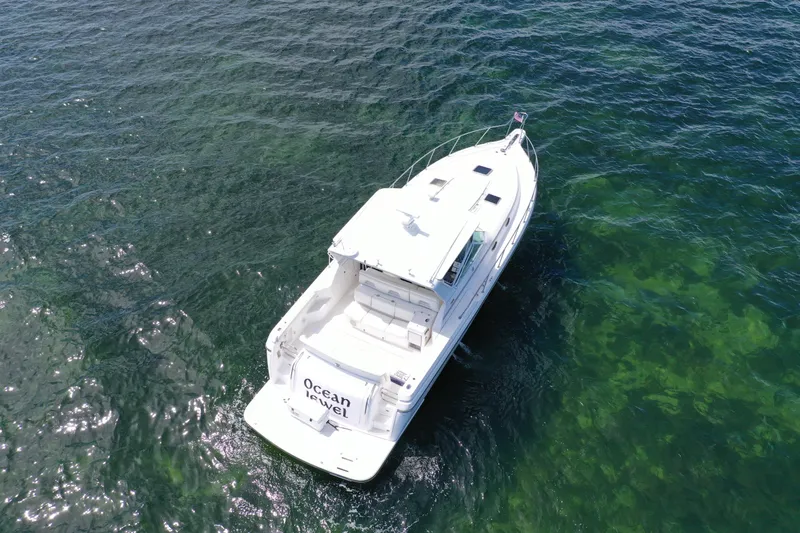  Yacht Photos Pics Aerial view of 1999 Tiara Yachts 4000 Express on clear green water.