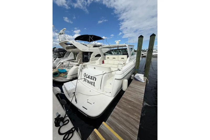  Yacht Photos Pics 1999 Tiara Yachts 4000 Express docked, named "Ocean Jewel," under a partly cloudy sky.