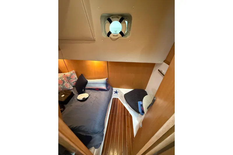 Yacht Photos Pics 1999 Tiara Yachts 4000 Express cabin interior with cozy bed and wooden flooring.