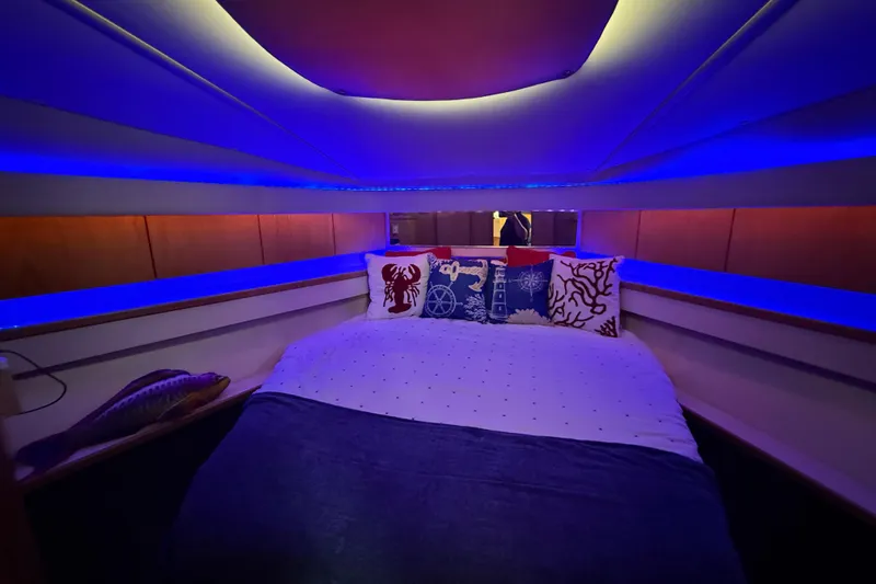  Yacht Photos Pics 1999 Tiara Yachts 4000 Express cabin with nautical-themed bedding and ambient blue lighting.
