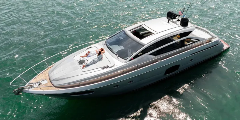  Yacht Photos Pics 2015 Pershing 62' yacht cruising on clear blue water, featuring sleek design and sunbathing area.