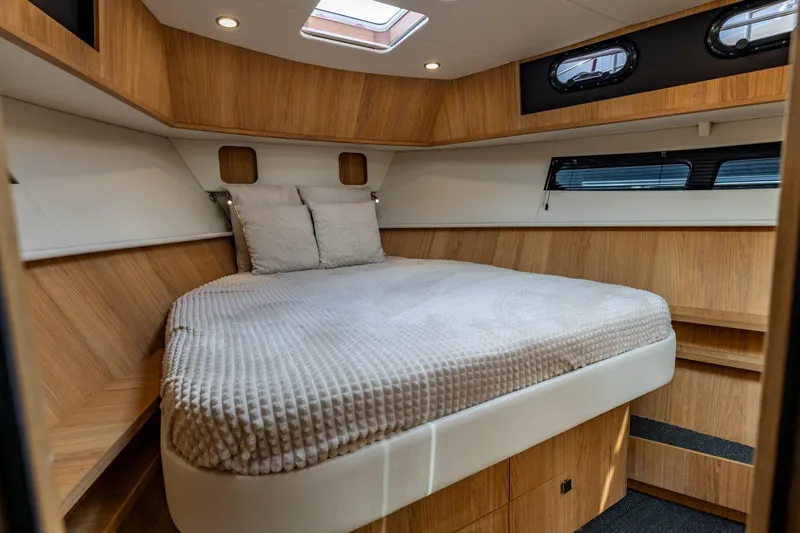  Yacht Photos Pics Luxurious cabin interior of 2024 Vripack 42 Open Kuip yacht with wood finish and cozy bedding.