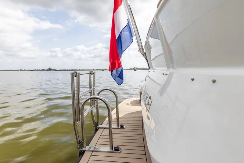  Yacht Photos Pics Vripack 42 Open Kuip yacht, 2024 model, with flag and swim ladder on calm water.