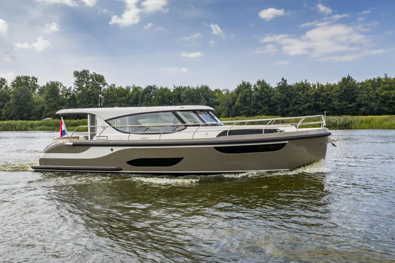  Yacht Photos Pics 2024 Vripack 42 Open Kuip yacht cruising on a serene river under a blue sky.