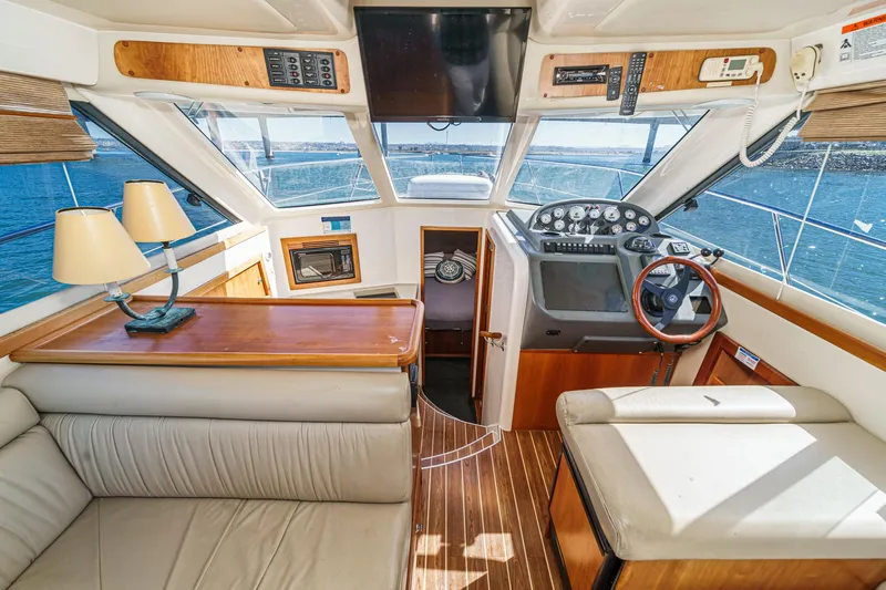 Lil' Breezy Yacht Photos Pics 2006 Riviera 33 Open Flybridge interior with helm, seating, and panoramic windows.