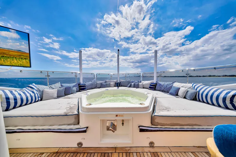 Natural 9 Yacht Photos Pics Luxurious Sunseeker 37 Metre Yacht 2009 with jacuzzi, striped cushions, and ocean view.