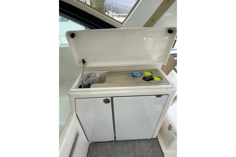 Sasea Yacht Photos Pics 2009 Tiara Yachts 4200 Open interior with open storage compartment and cleaning supplies.