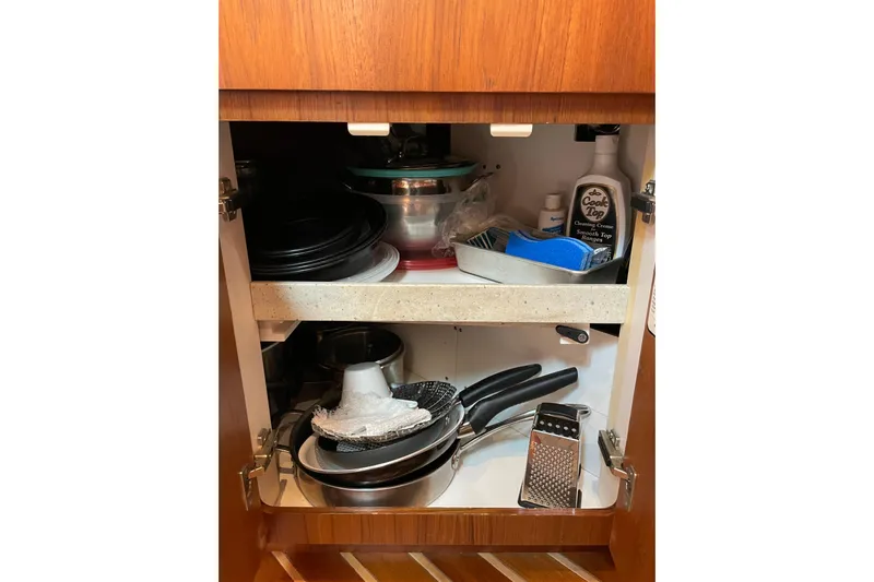 Sasea Yacht Photos Pics Kitchen cabinet in 2009 Tiara Yachts 4200 Open, storing cookware and cleaning supplies.
