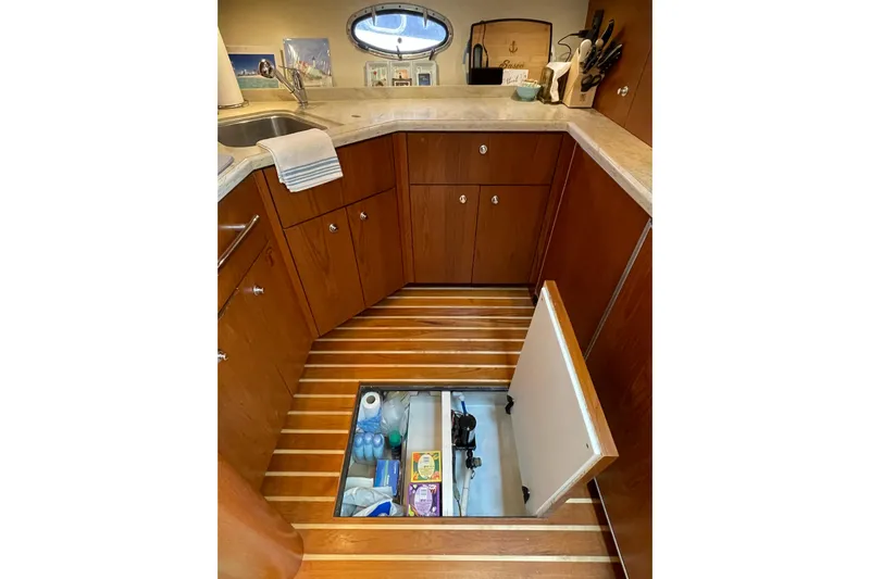 Sasea Yacht Photos Pics 2009 Tiara Yachts 4200 Open galley with hidden floor storage, wooden cabinets, and countertop.