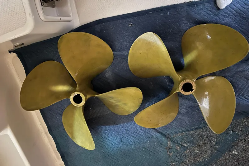 Sasea Yacht Photos Pics Two brass propellers for a 2009 Tiara Yachts 4200 Open on a blue mat.