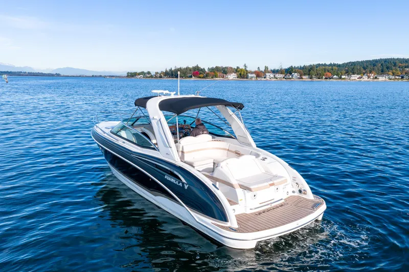  Yacht Photos Pics 2013 Formula 310 Sun Sport boat cruising on a serene lake with scenic shoreline.