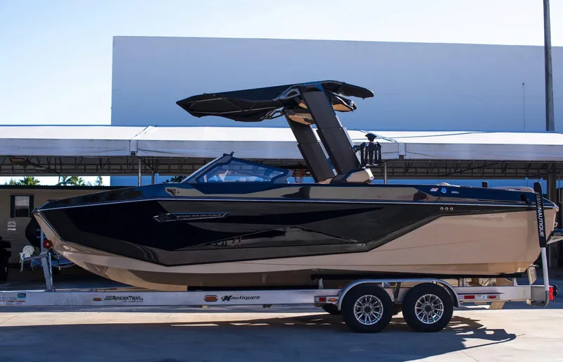  Yacht Photos Pics 2025 Nautique Super Air Nautique G25 boat on trailer, sleek design, outdoor setting.