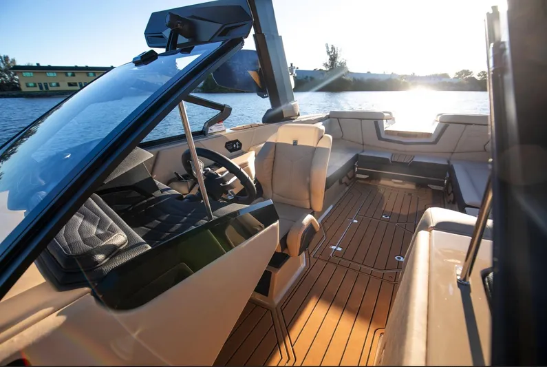  Yacht Photos Pics 2025 Nautique Super Air Nautique G25 interior with luxurious seating and modern dashboard on a sunny day.