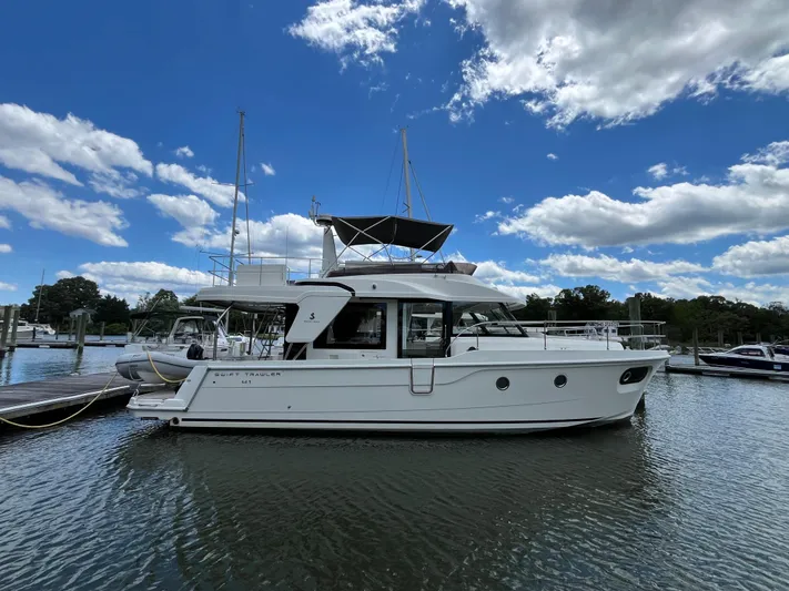  Yacht Photos Pics 2023 Beneteau Swift Trawler 41 Fly moored at a marina under a blue sky.