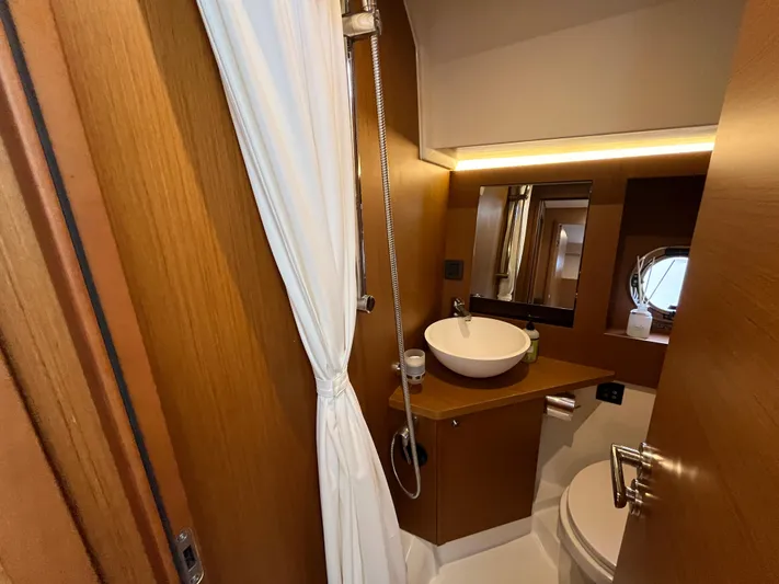  Yacht Photos Pics Bathroom interior of 2023 Beneteau Swift Trawler 41 Fly, featuring modern fixtures and wood accents.