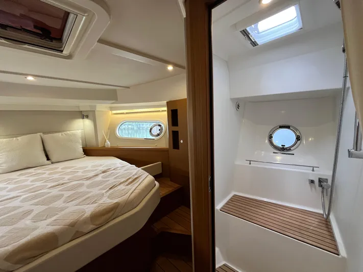  Yacht Photos Pics 2023 Beneteau Swift Trawler 41 Fly cabin interior with bed and porthole view.
