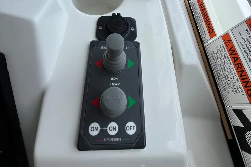  Yacht Photos Pics Control panel of 2023 Beneteau Swift Trawler 41 Fly with thruster controls and warning labels.