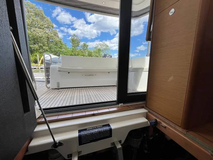  Yacht Photos Pics 2023 Beneteau Swift Trawler 41 Fly interior view with outdoor seating and blue sky.