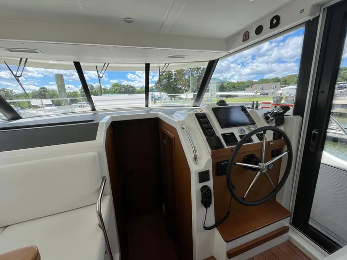  Yacht Photos Pics Interior helm of 2023 Beneteau Swift Trawler 41 Fly with modern controls and panoramic windows.