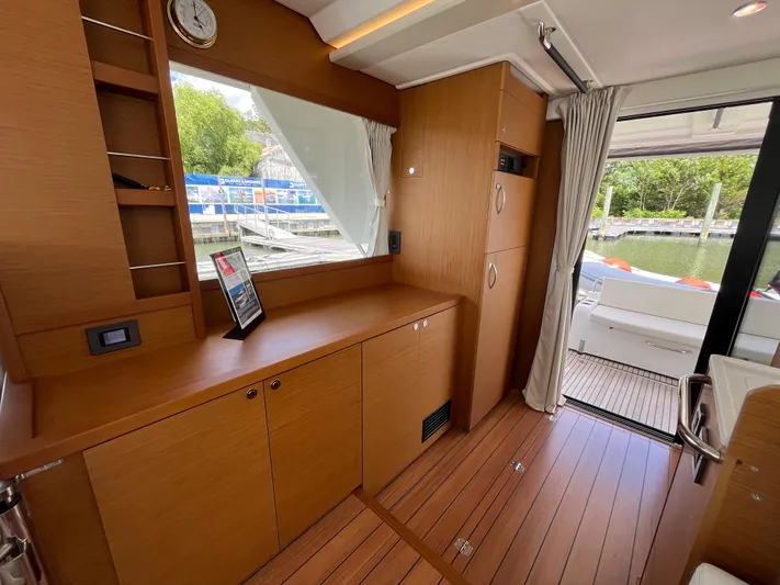  Yacht Photos Pics Interior of 2023 Beneteau Swift Trawler 41 Fly, featuring wood cabinetry and outdoor view.