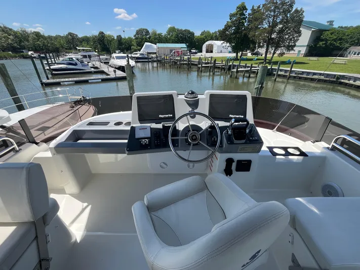  Yacht Photos Pics Helm of 2023 Beneteau Swift Trawler 41 Fly at marina, featuring modern navigation equipment.