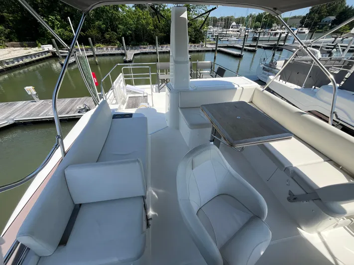  Yacht Photos Pics 2023 Beneteau Swift Trawler 41 Flybridge with seating and table, docked at marina.